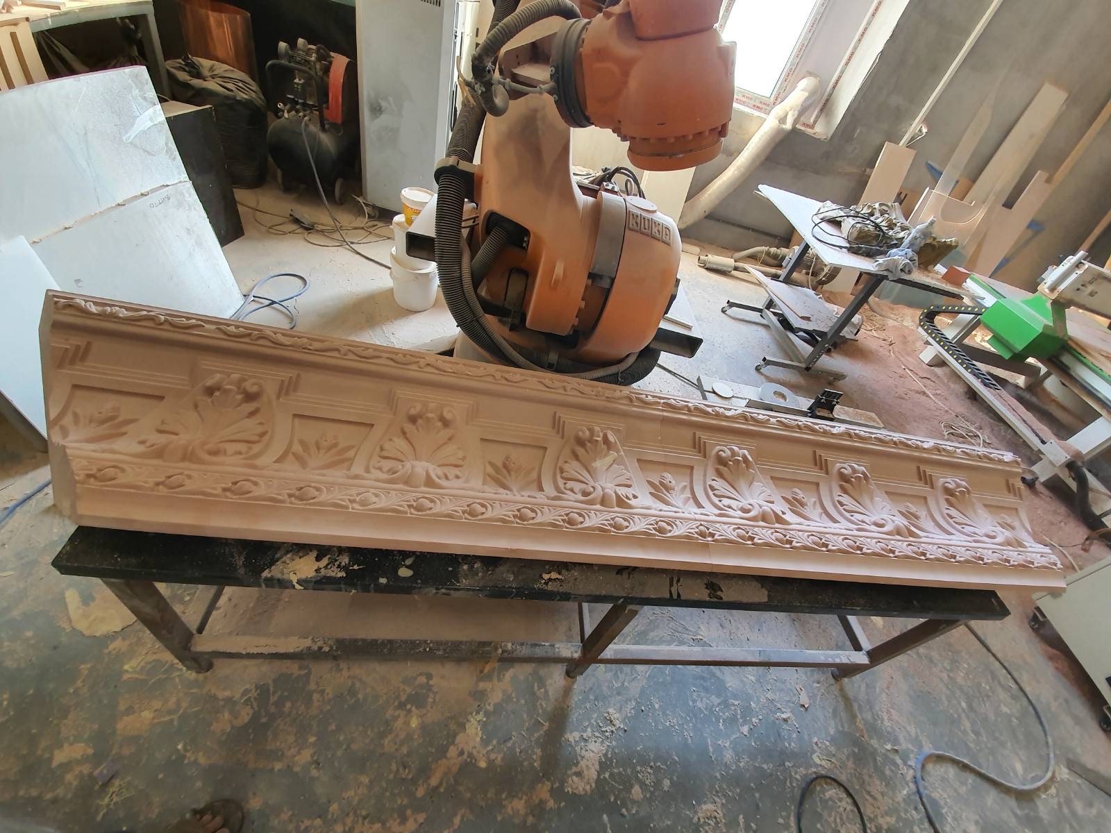 A robotic arm beside a carved cornice