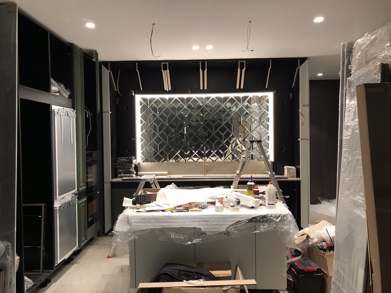 The mirrored kitchen splashback lit for the first time
