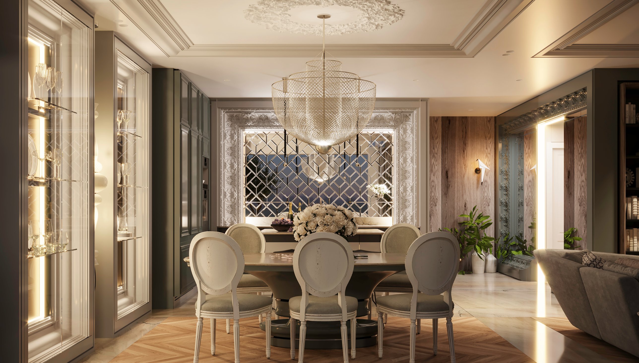 Dining room with a round table, oval-back chairs and a wire-mesh chandelier before a mirrored wall framed in classical ornament
