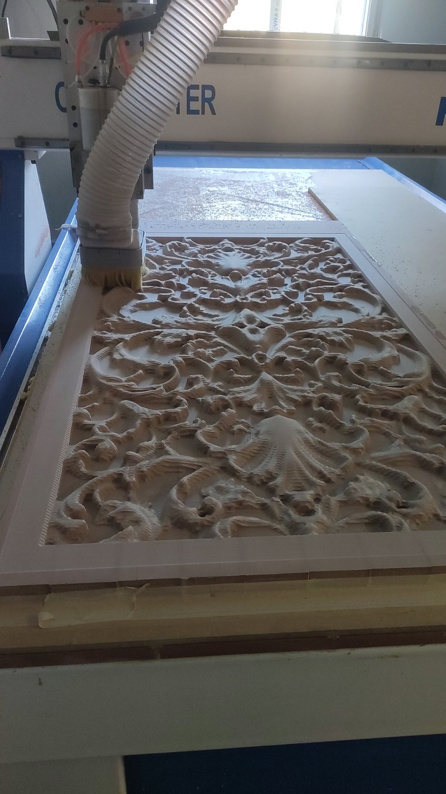 An ornamental panel being carved on the CNC machine