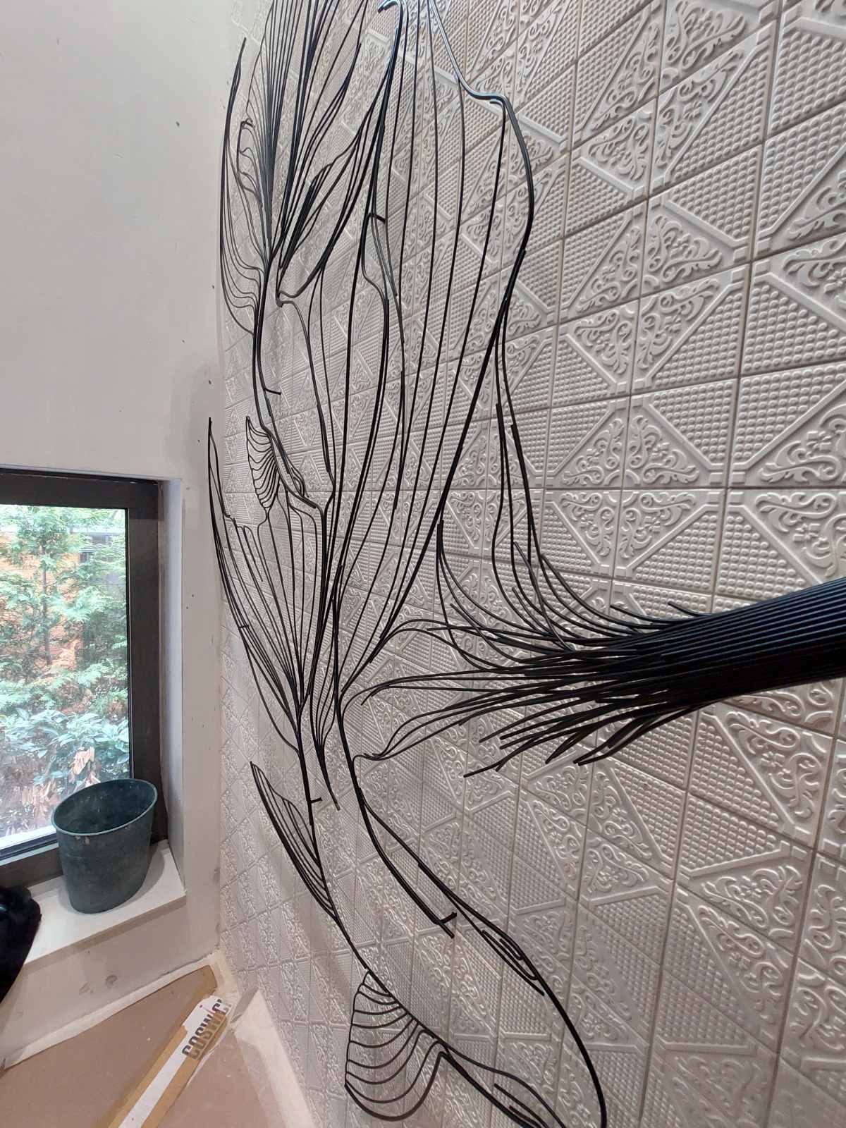 The black wire koi taking shape against the tiles