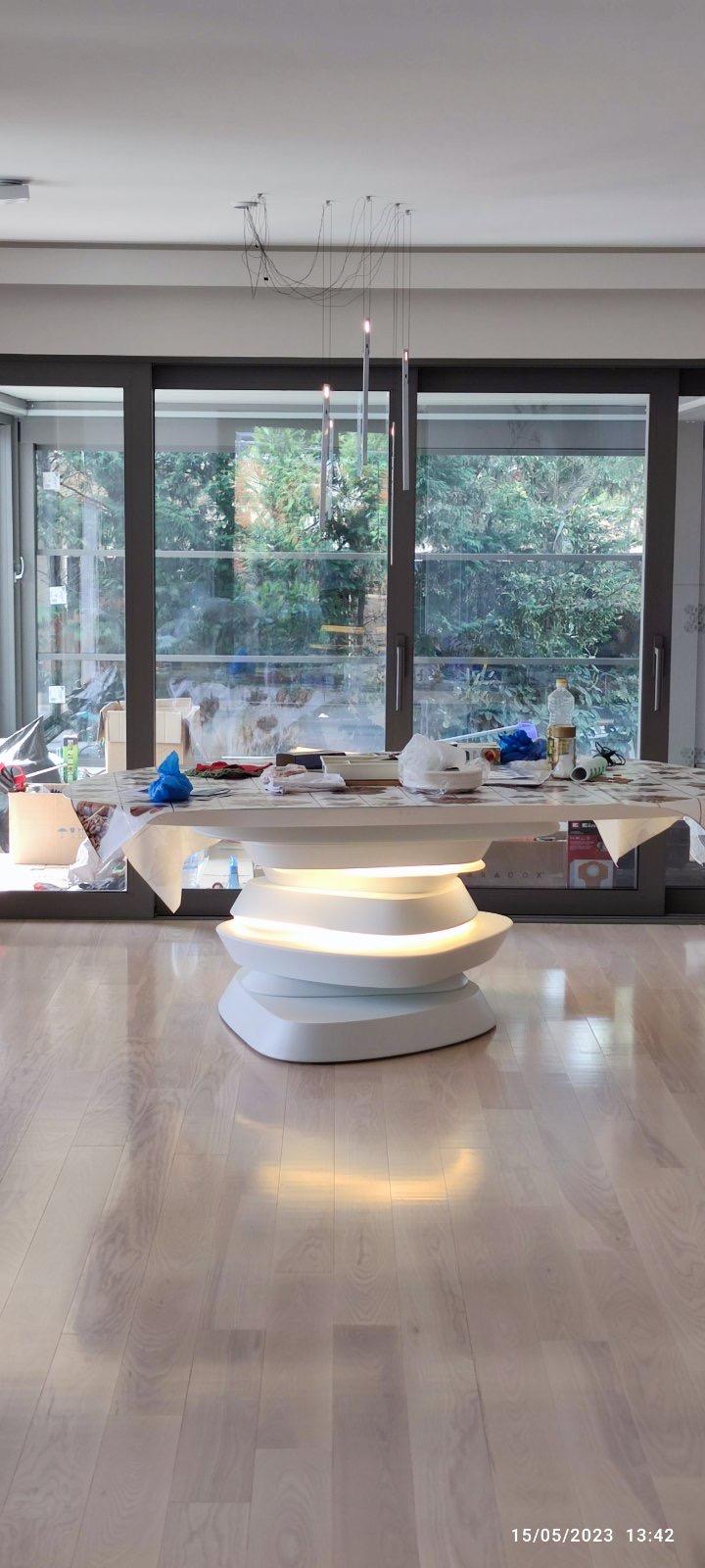 The layered dining table installed, its light tested