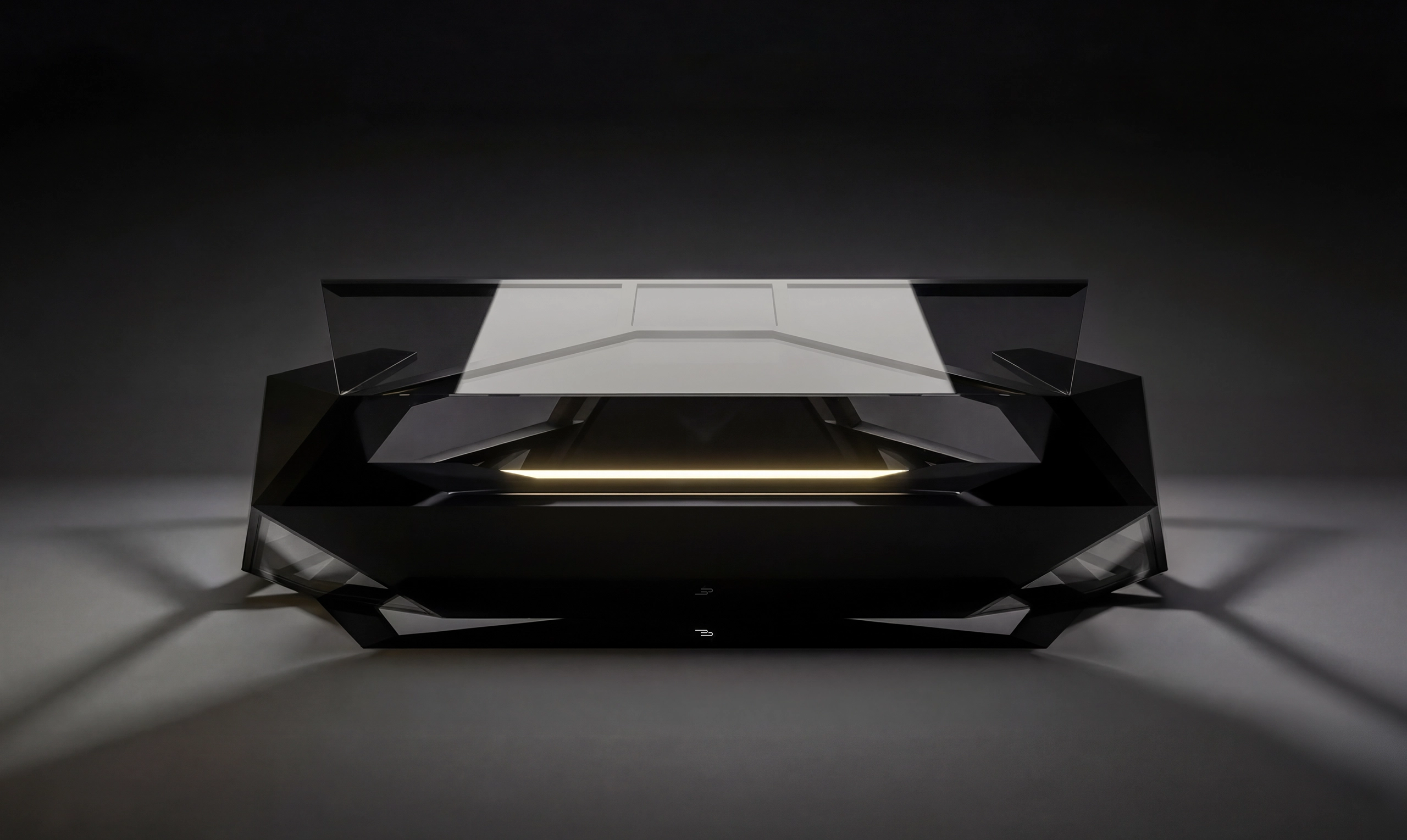 The desk with its glass top, faceted black body and central line of warm light