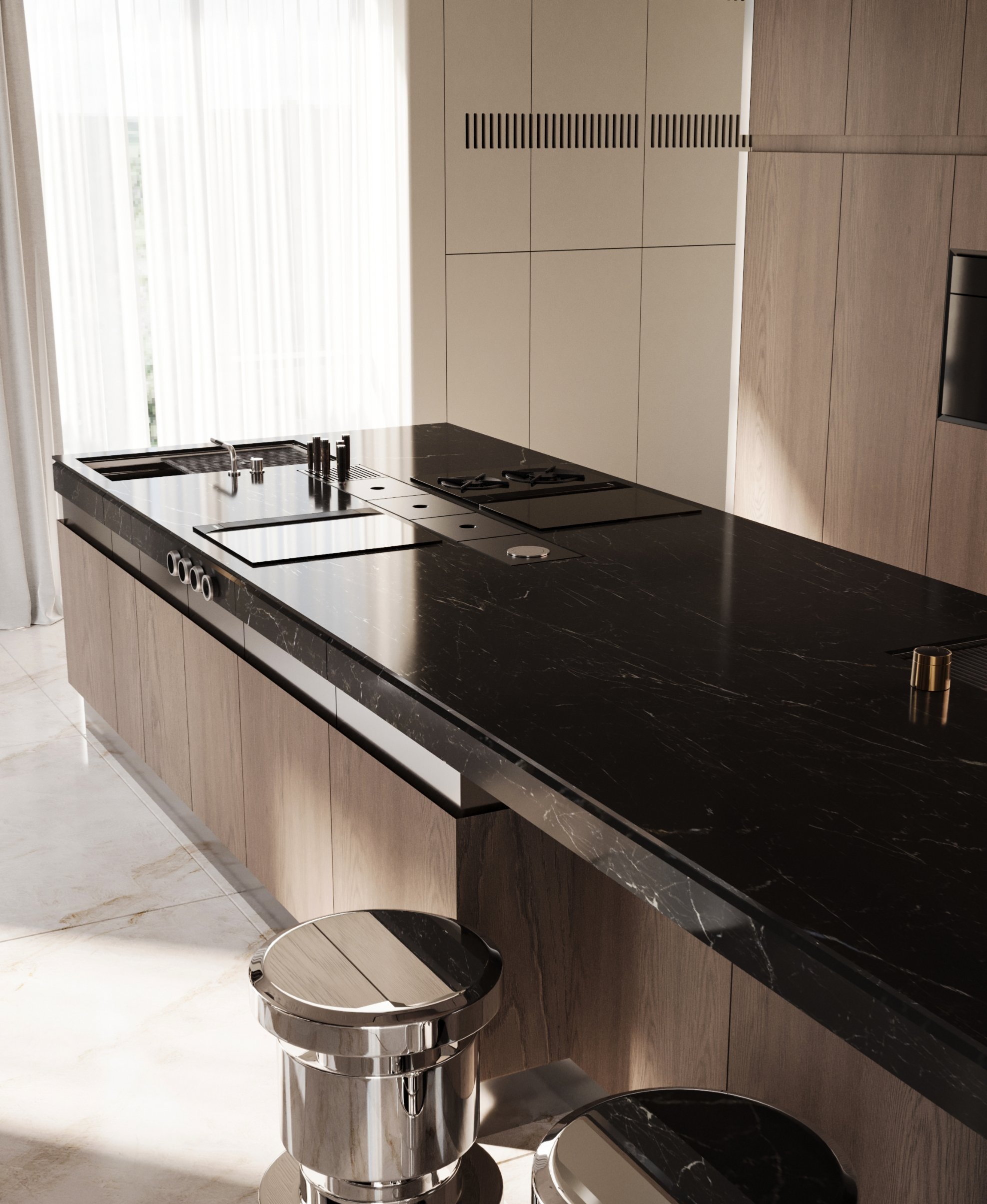 The broad black stone island with polished metal stools in sunlight