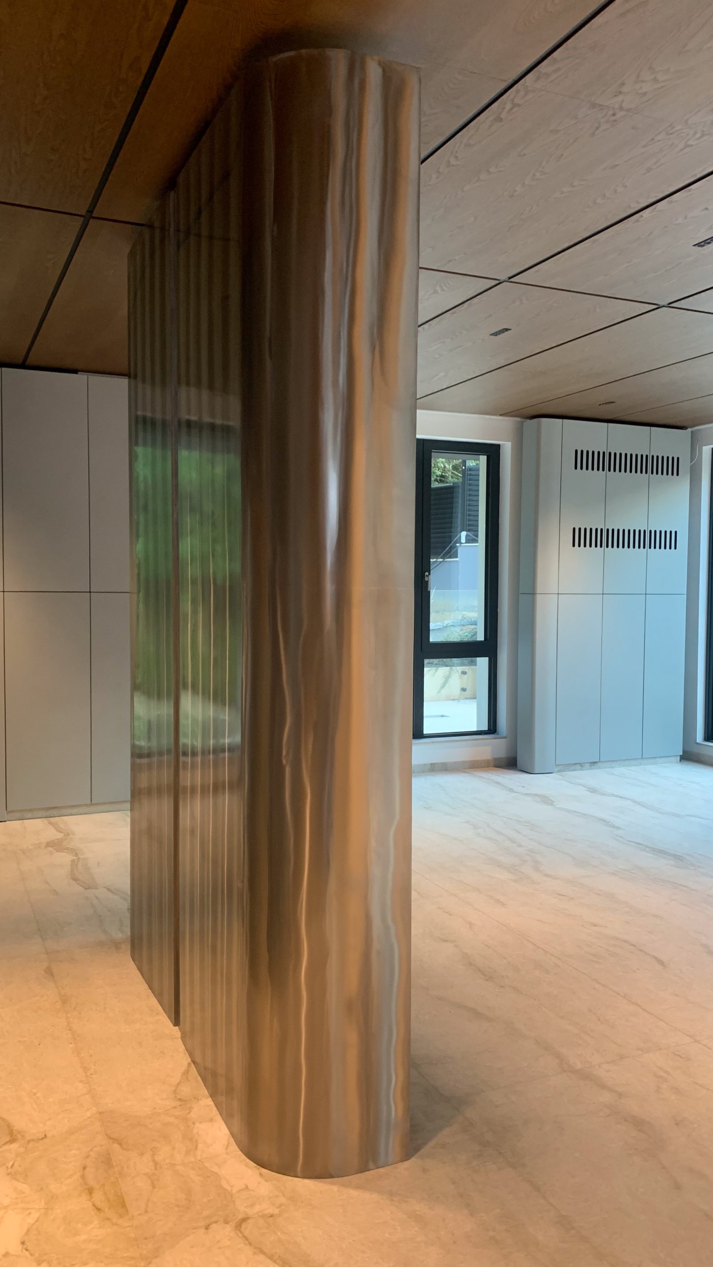 A rounded brushed-metal column in the open living space