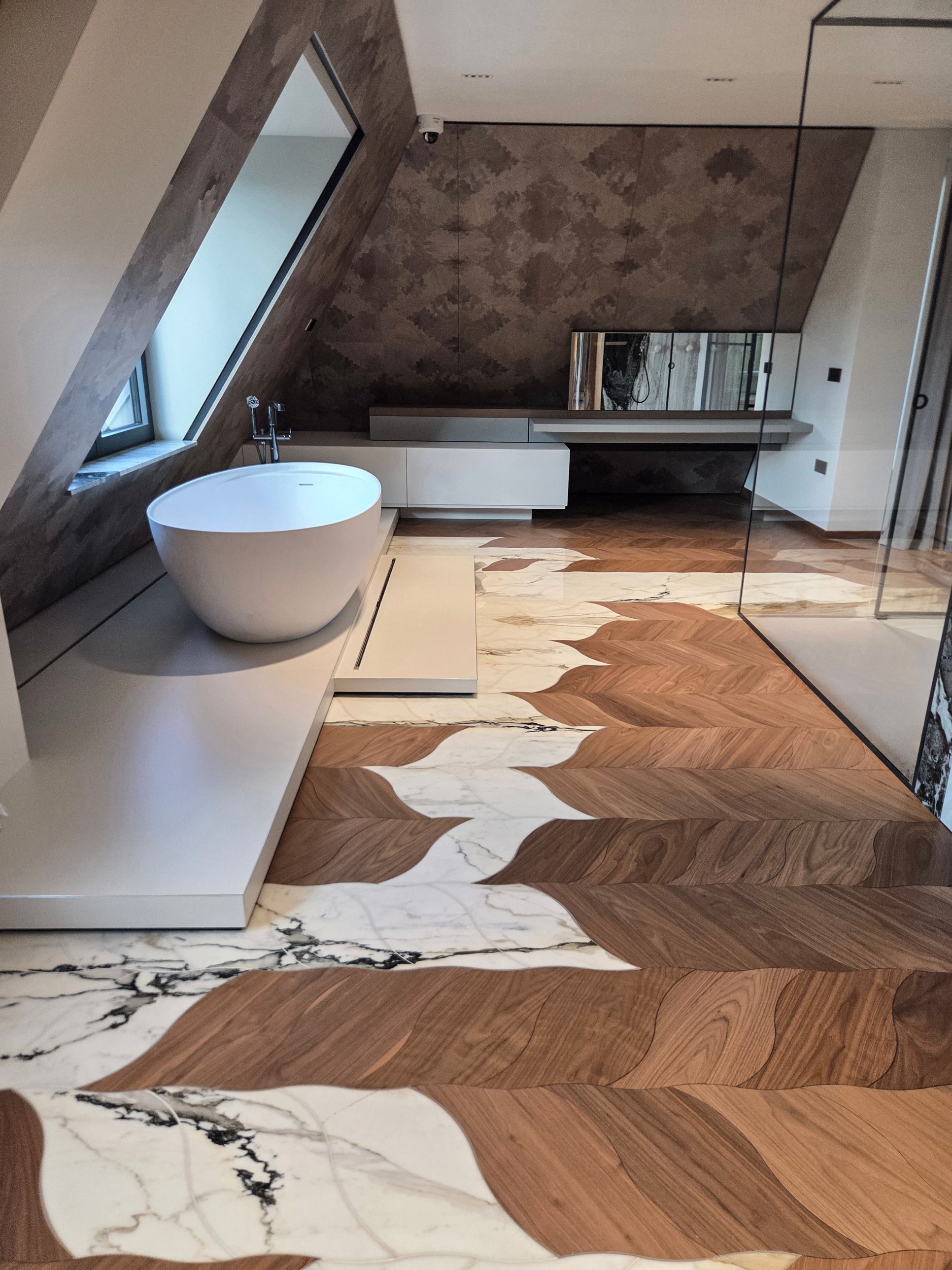 The finished bathroom: timber leaves meeting white veined stone around the raised bath platform