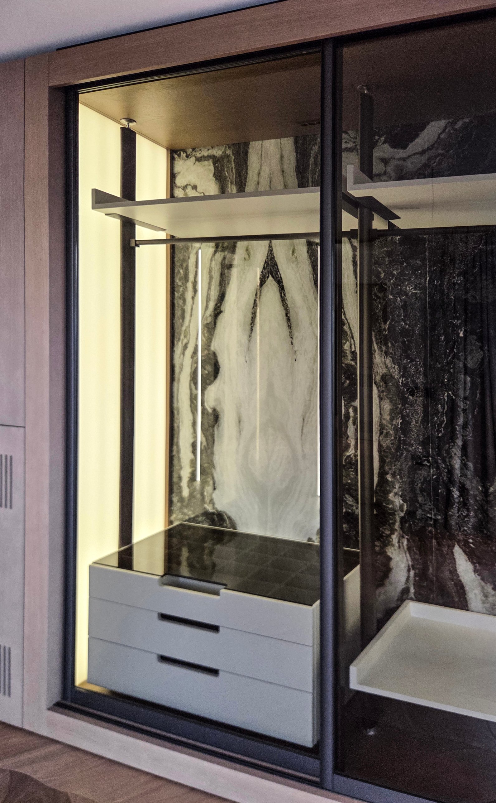A lit wardrobe with a veined stone back