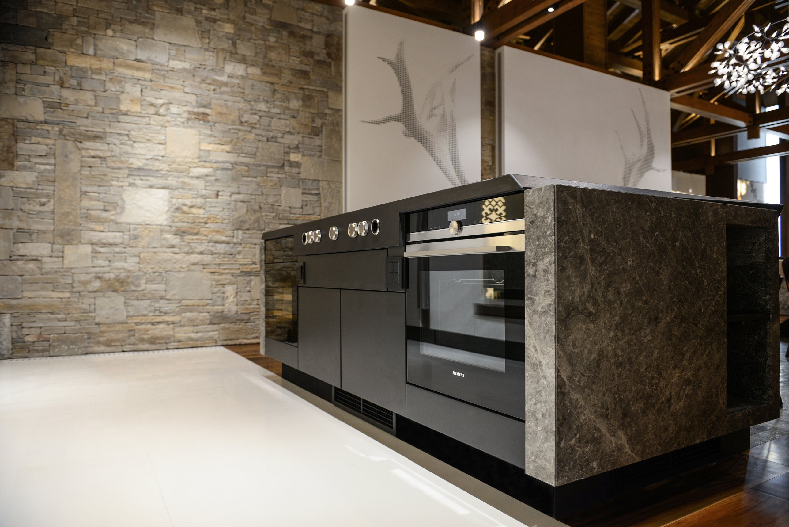 The cooking side of the island before a natural stone wall and the stag panels
