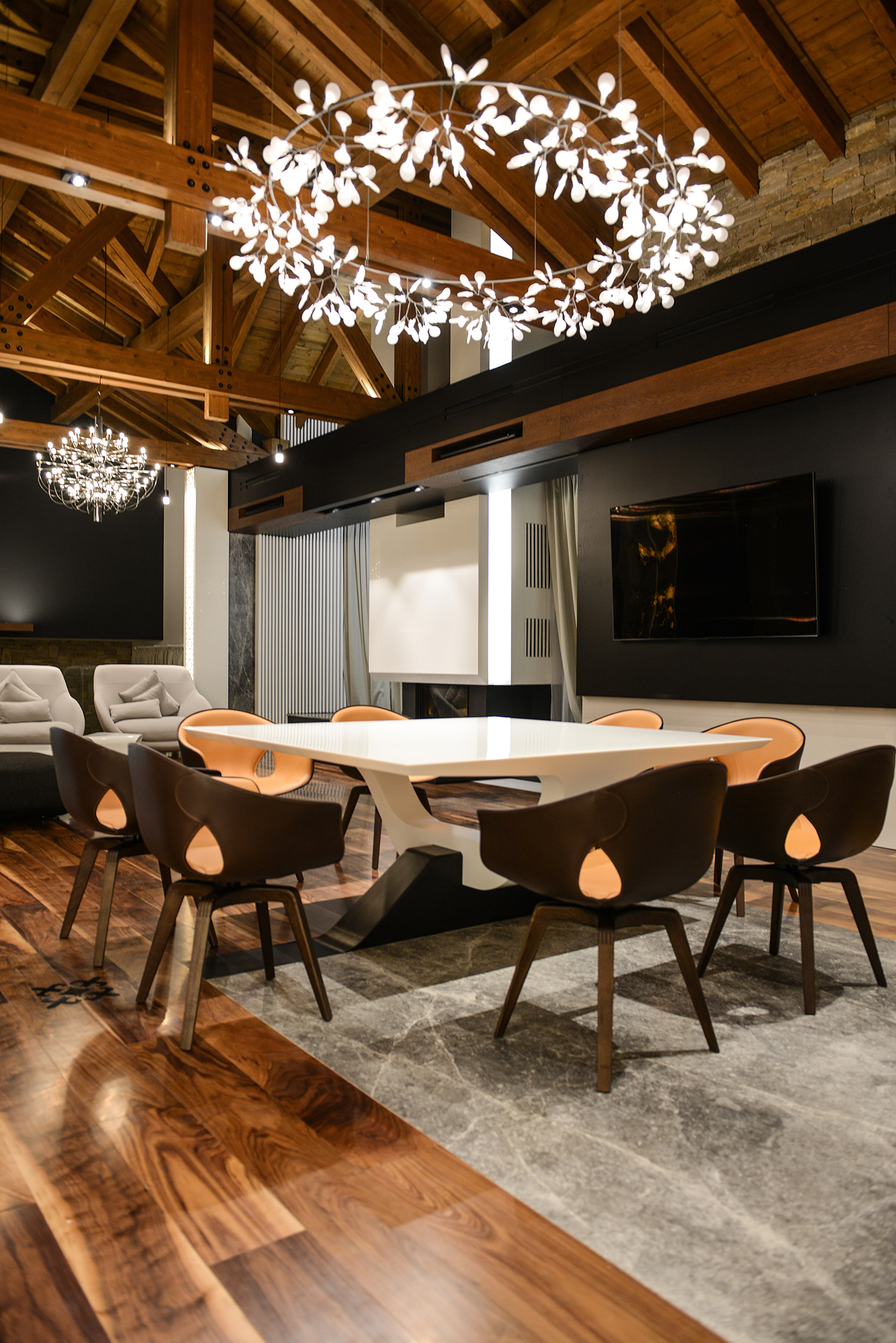 Dining chairs around the white table beneath the branching chandelier