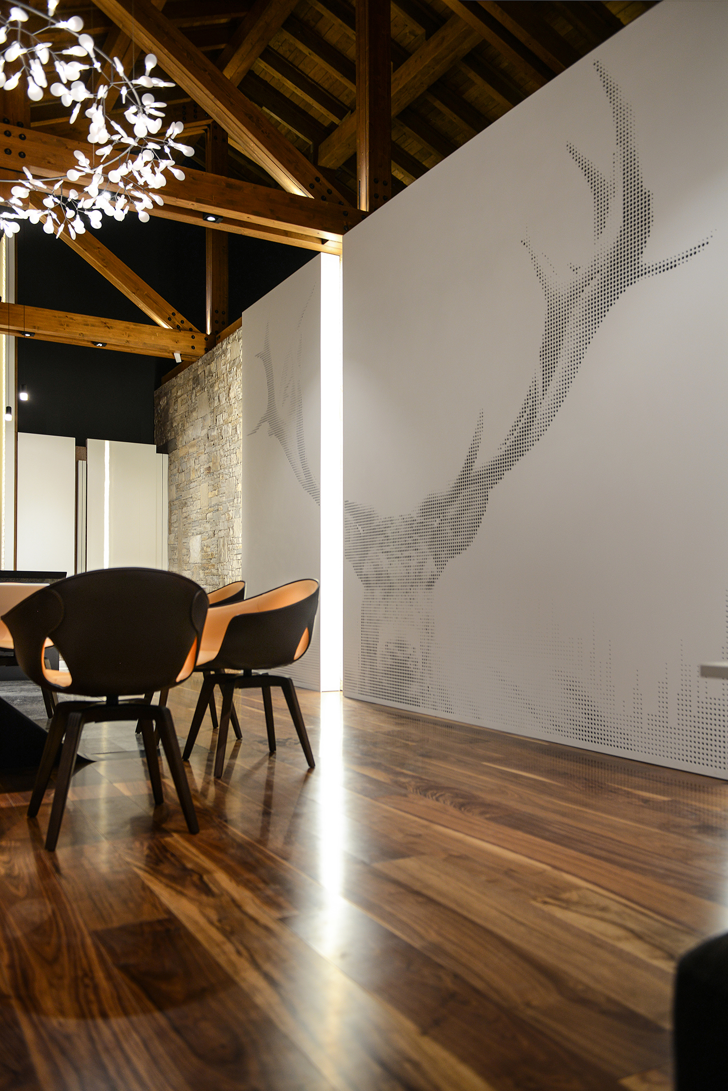 The stag panels rising toward the timber roof beside the dining chairs