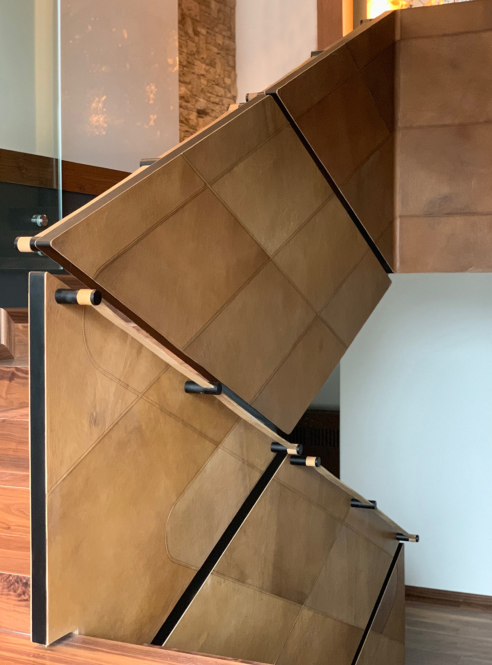 The leather-clad balustrade folding with the stair