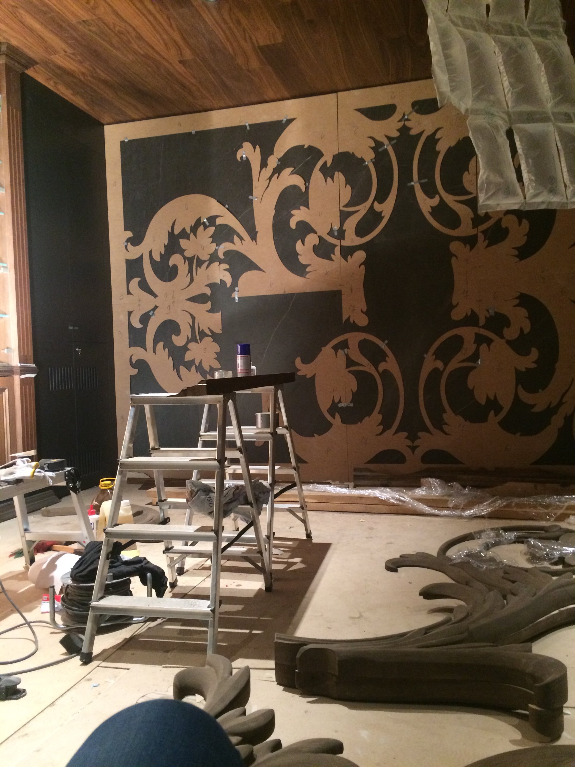 Ornamental relief being fitted against dark stone panels