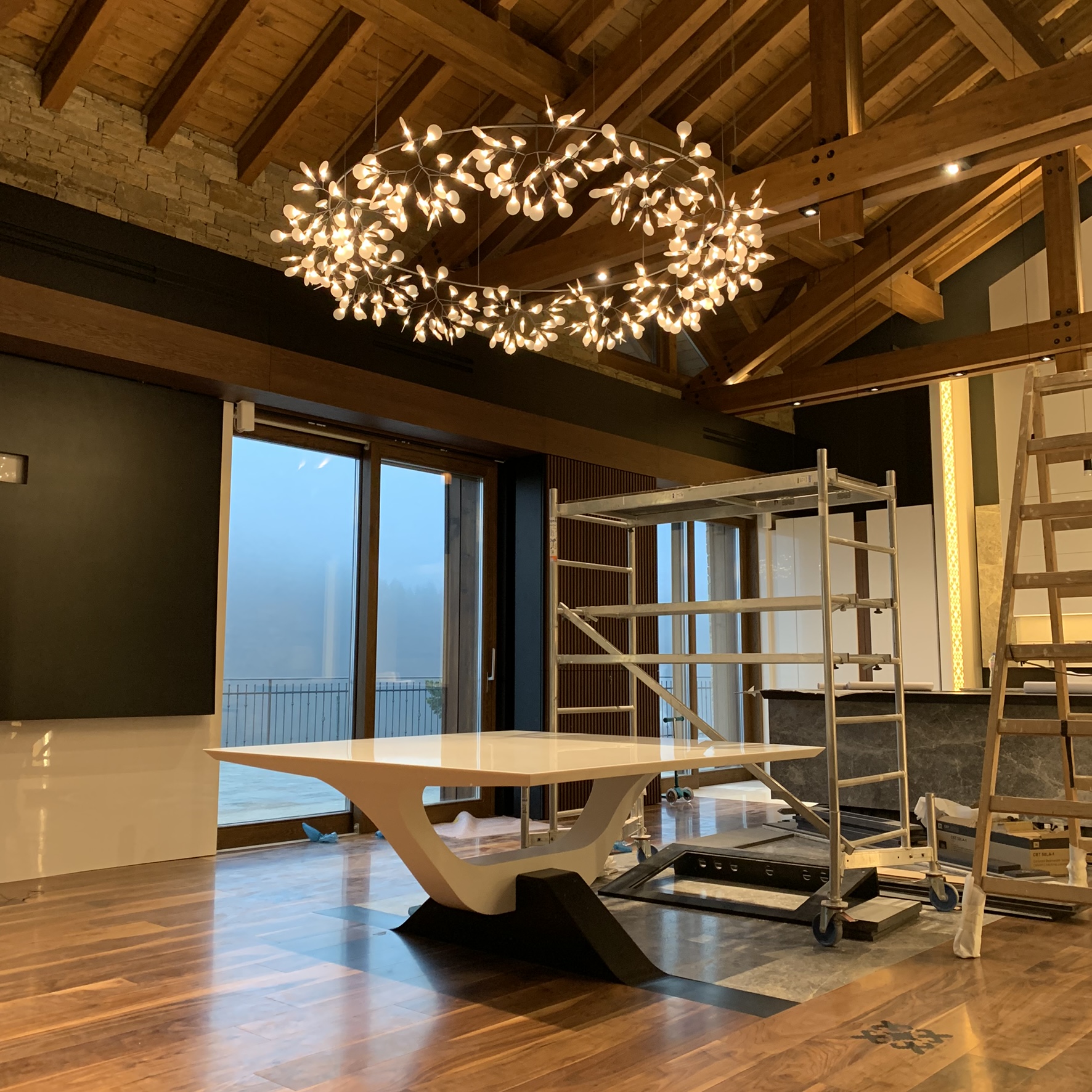 The dining table beneath the chandelier during installation