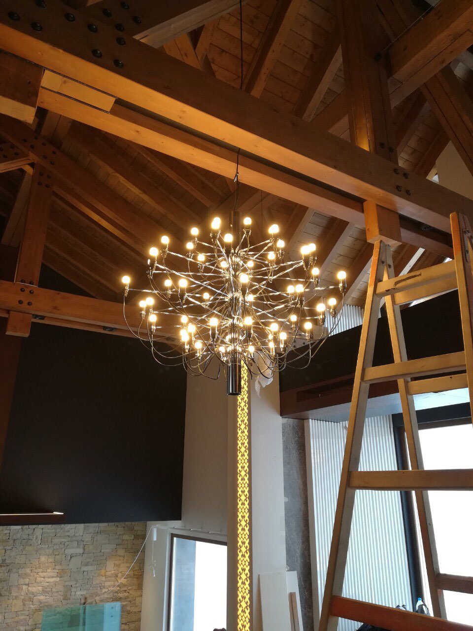The chandelier installed beneath the roof trusses