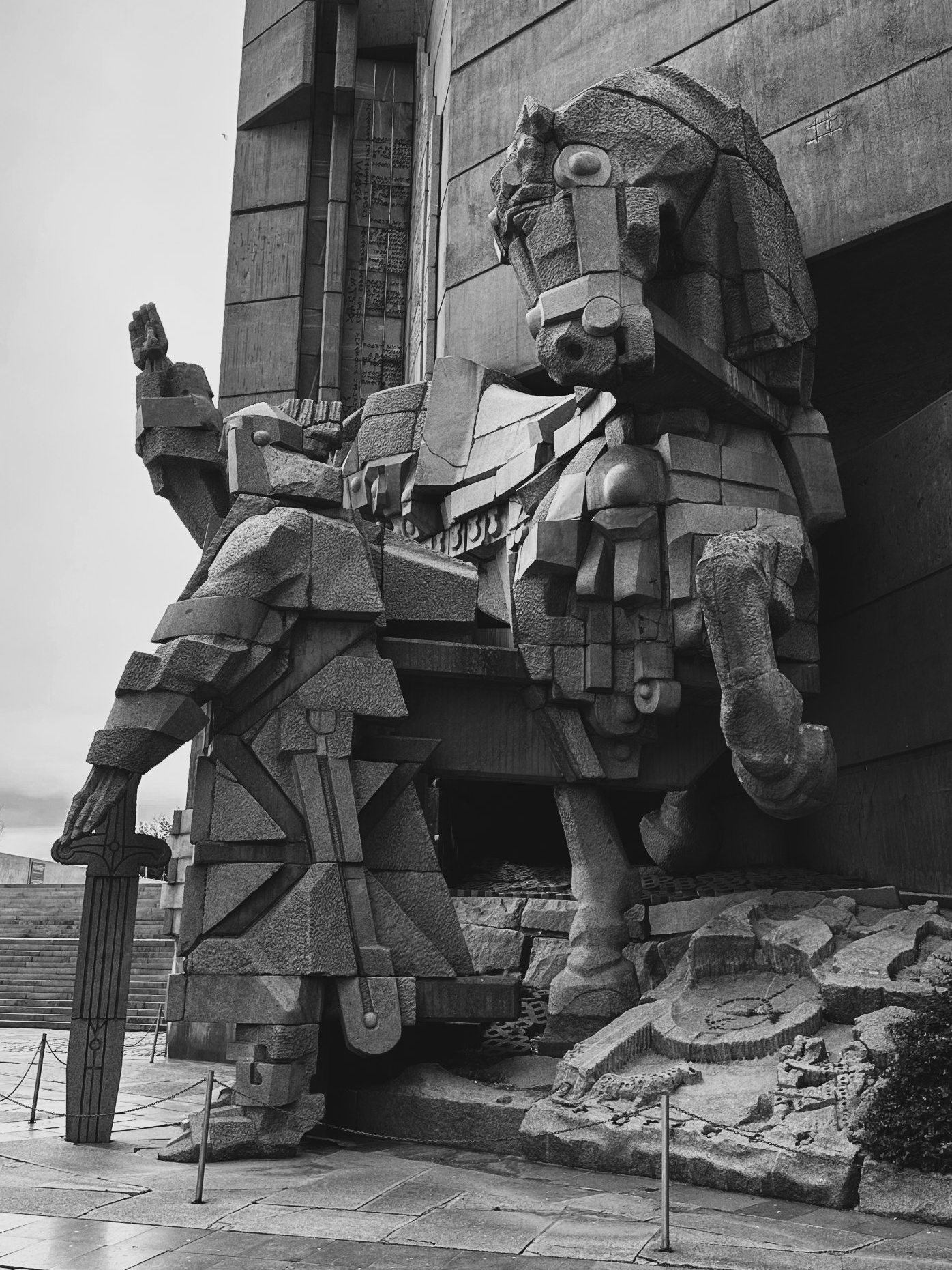 A stone horseman before the concrete walls of the Founders of the Bulgarian State Monument