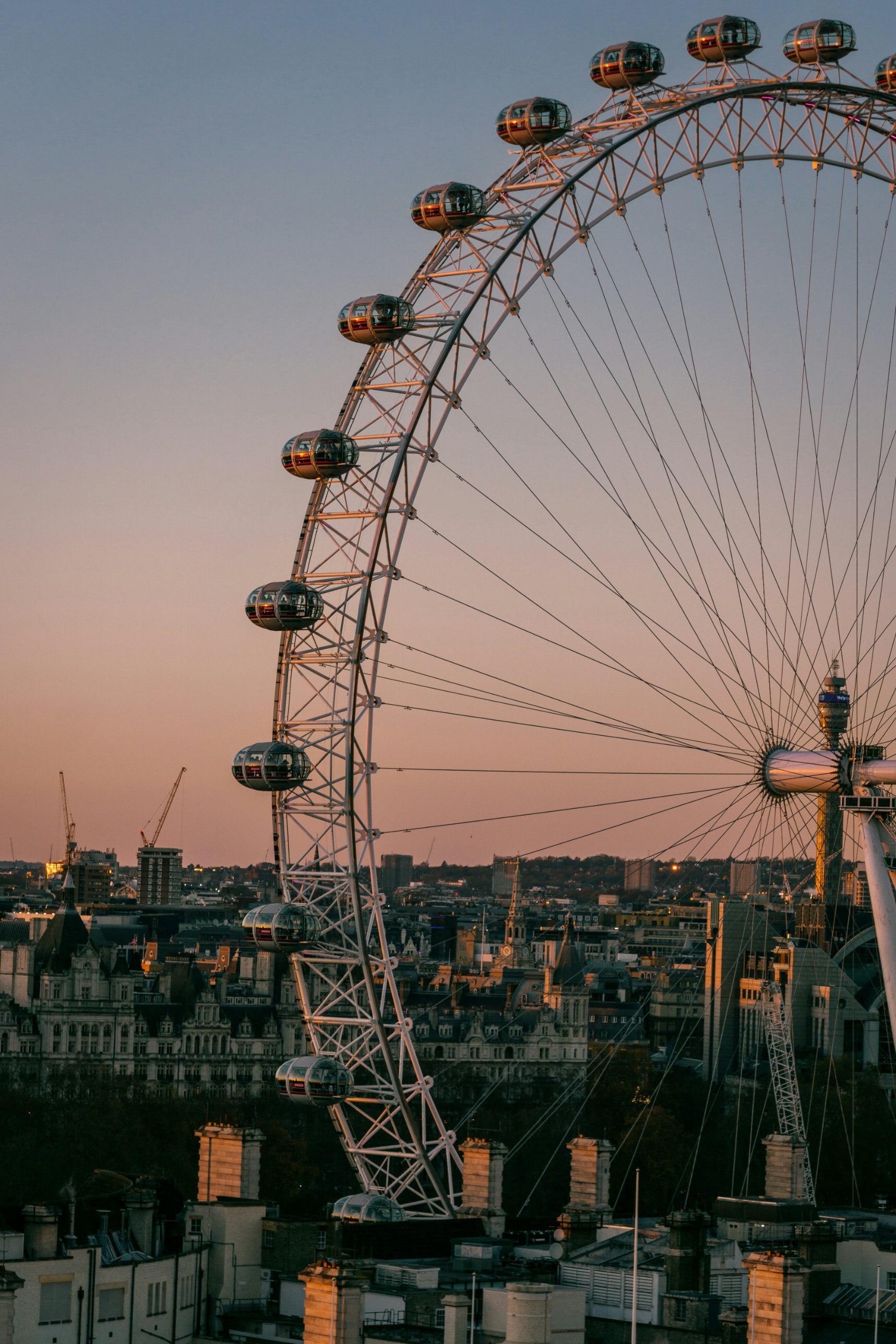 The London Eye against a pink evening sky above Whitehall