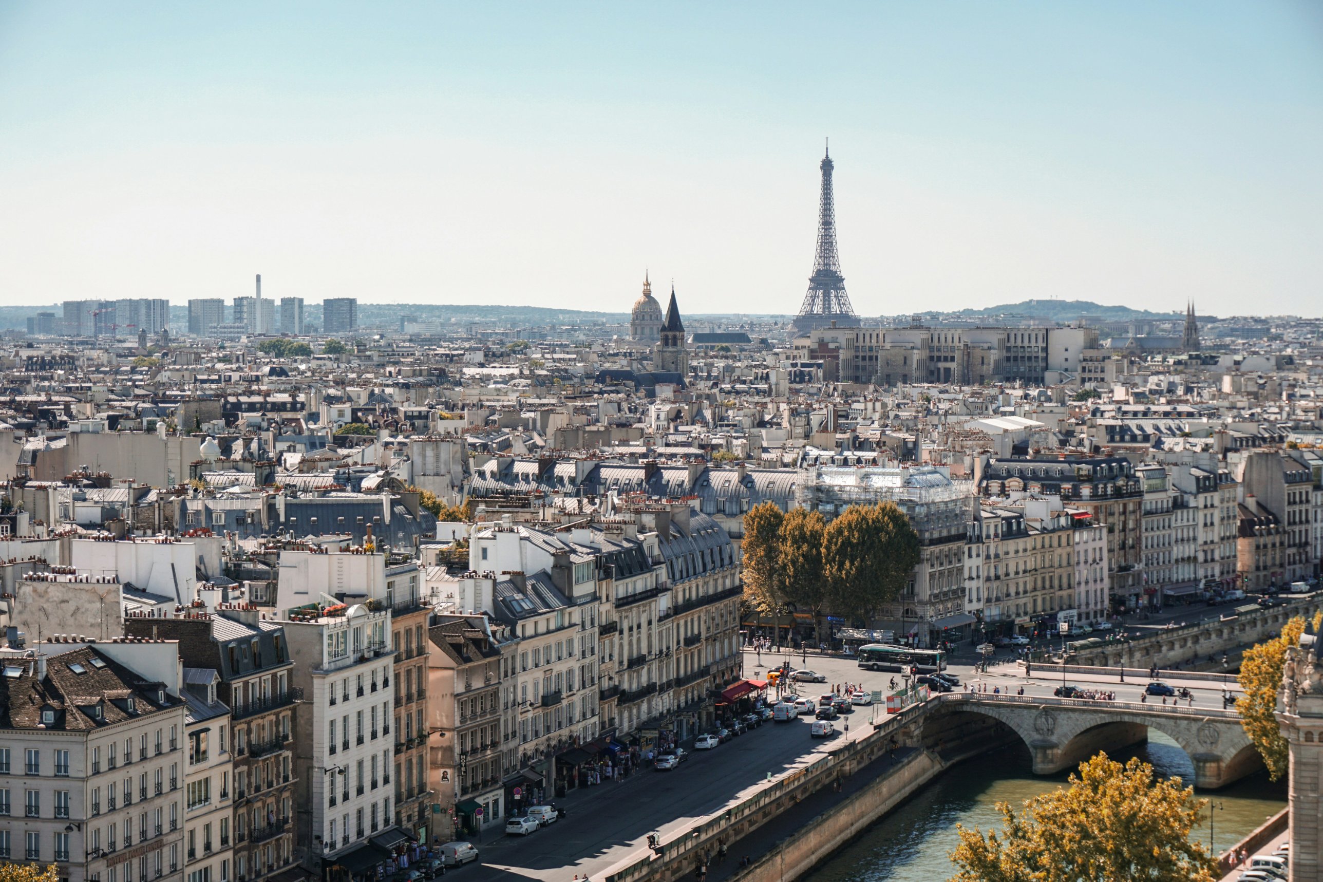 Paris rooftops along the Seine, with the Eiffel Tower and the dome of Les Invalides on the horizon