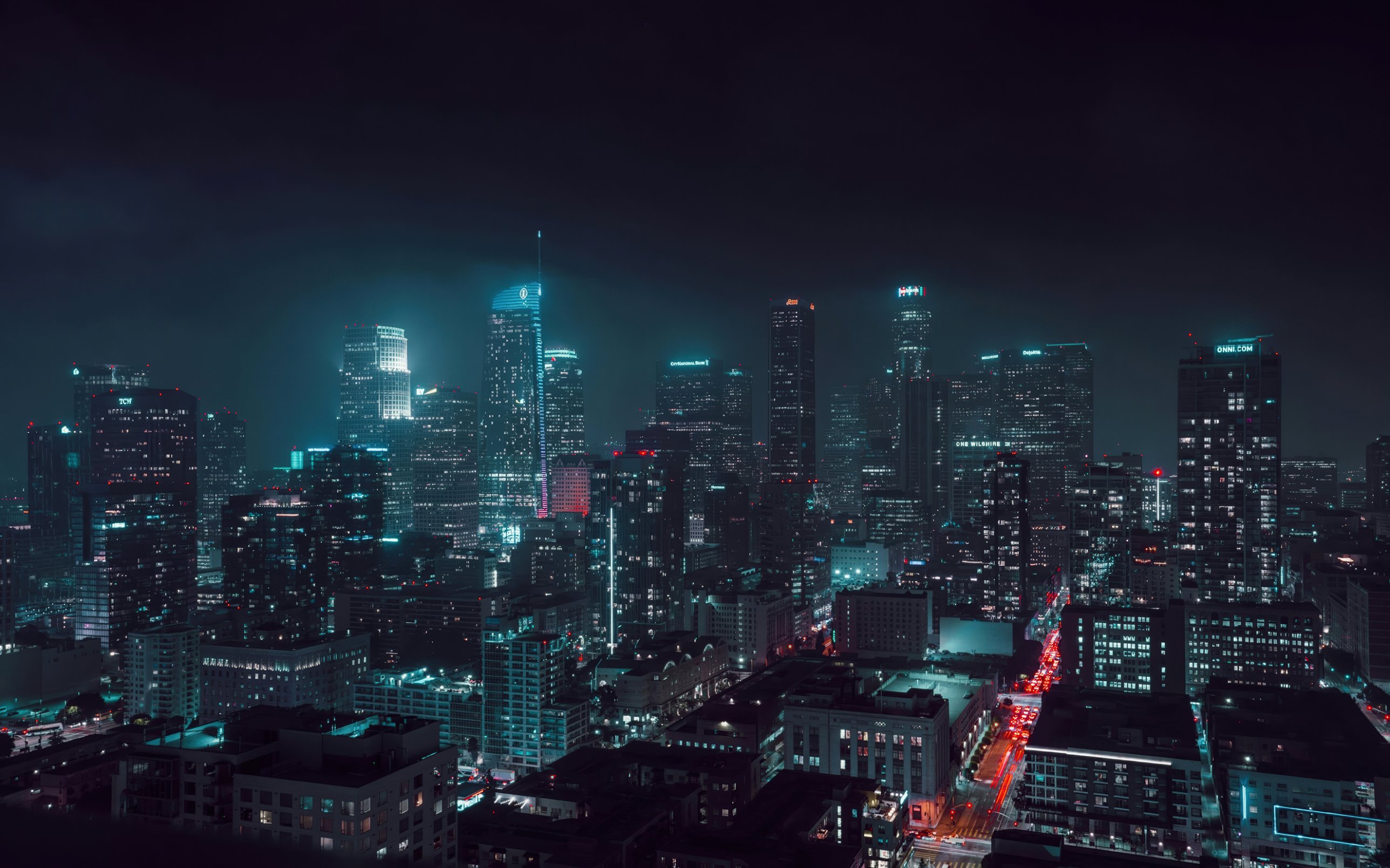 Downtown Los Angeles at night, its towers rising into low cloud