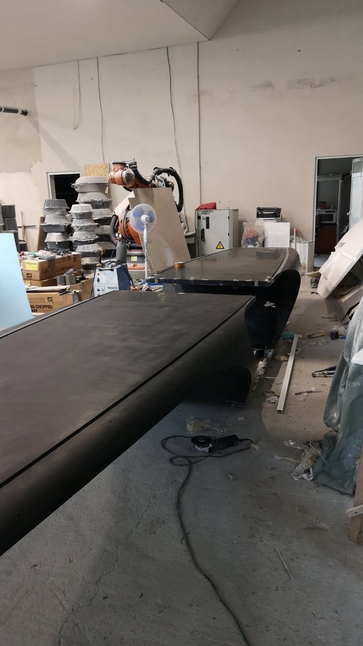 The table top beside the robotic arm in the workshop